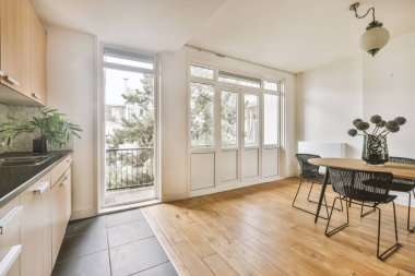 Balkon mutfak masasının yanındaki kapıları açtı.