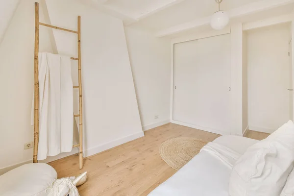 Single bed in the bedroom with a shelf to put towel