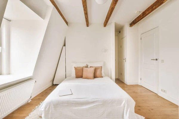 Empty bedroom with large double white bed