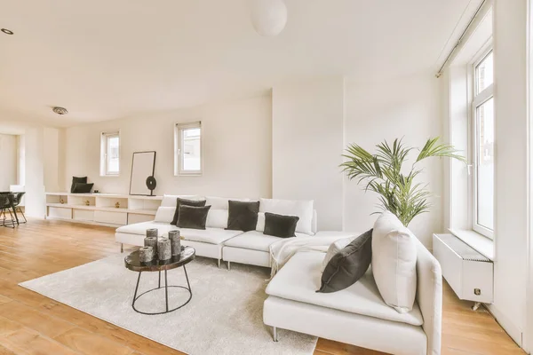 White colored sofa with white and black pillows on it in the hall