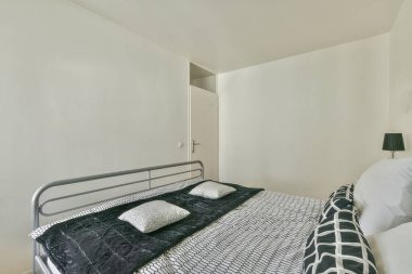 Minimalist komodinli geniş, parlak bir yatak odası ve geniş bir panoramik pencere.