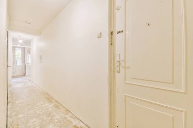 Dar, boş koridor lambalarla aydınlatılmış, minimal tarzda modern dairenin içi