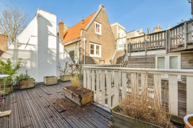 Oturma alanı ve ahşap çitlerin yanındaki küçük bahçesi olan düzgün asfaltlı bir avlu.