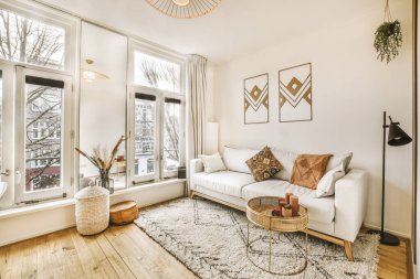 Rahat koltuklar ve ahşap masa modern dairenin oturma odasının penceresinin yanındaki saksı bitkilerinin yanına yerleştirildi.