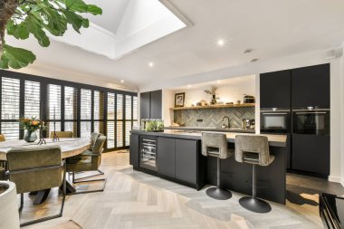 Geniş, parlak mutfak, yemek alanı, modern tasarım ve panoramik pencereler.