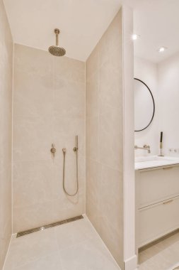 Parlak bir banyoda modern duş kabini.
