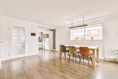 Çağdaş dairenin pencerelerine karşı rahat kanepesi ve televizyonu olan oturma odası.