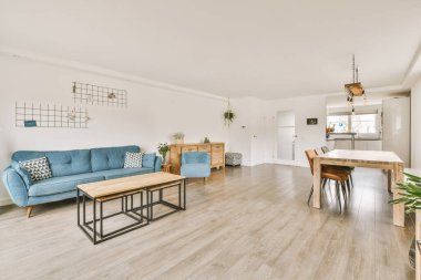 Çağdaş dairenin pencerelerine karşı rahat kanepesi ve televizyonu olan oturma odası.