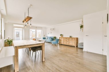 Çağdaş dairenin pencerelerine karşı rahat kanepesi ve televizyonu olan oturma odası.