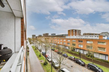 Eski tuğla binaların panoramik manzarası. Balkondan küçük balkon tuğlalı binaların park yerleri ve ağaçları.