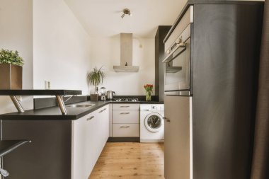 Modern bir mutfak odasında beyaz ve siyah mutfak aletleri.