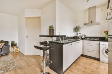 Modern bir mutfak odasında beyaz ve siyah mutfak aletleri.