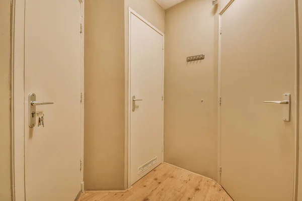 Corridor with the access to the cream colored doors