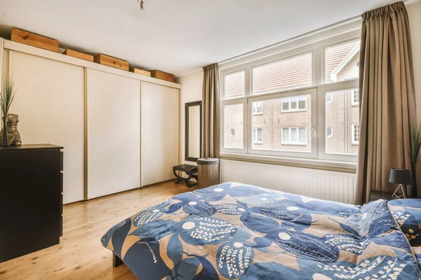 明るい寝室に青い毛布と枕付きのダブルベッド — ストック写真