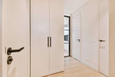 Işık dar koridor, beyaz duvarlarda birçok kapı ve kereste zemininde parlayan lamba