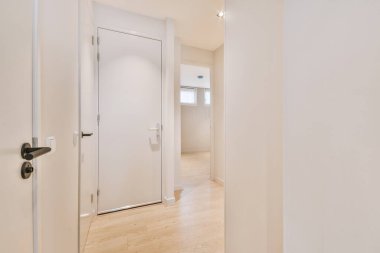 Işık dar koridor, beyaz duvarlarda birçok kapı ve kereste zemininde parlayan lamba