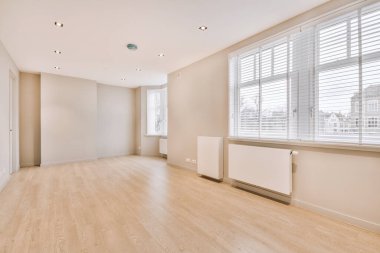 Evdeki boş ışık odasında, beyaz duvardaki plastik pencere ve radyatör.