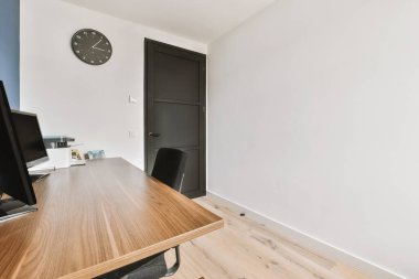 Odanın içinde ahşap masa ve perdeli raflar var.