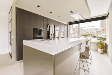 Çağdaş dairenin kapısının ve yemek alanının yakınındaki yastıklı rahat bir kanepe.