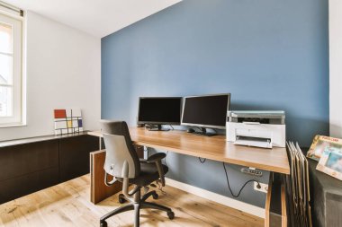 Odanın içinde ahşap masa ve perdeli raflar var.