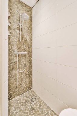 Duş muslukları cam bölmenin yanındaki fayanslı duvara bağlı ve evdeki tuvaletteki süs pervazı.