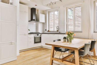 Köşedeki dolaplar ve sandalyeli masa günümüzün düz mutfağında.