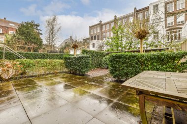 Açık hava eğlencesi için yemek alanı olan minimalist, parlak ve manzaralı bir arka bahçe.