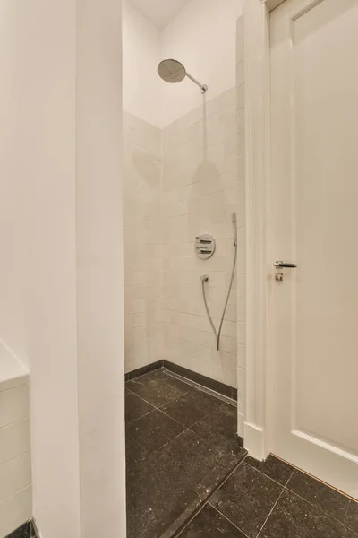 コンクリート壁に対するフラッシュトイレと浴槽の近くに位置するシンクとミラー — ストック写真