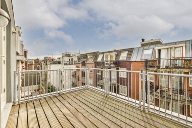 Dar tuğlalı balkon, metal parmaklıklı ve camlı kapı.