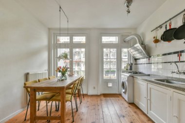 Geniş, parlak mutfak, yemek alanı, modern tasarım ve panoramik pencereler.