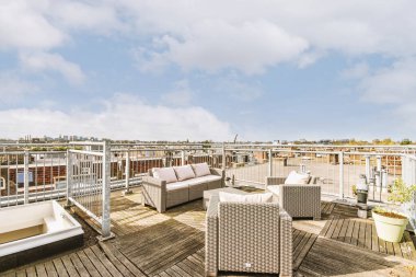 Temiz asfalt veranda, oturma alanı ve şehir manzarası.