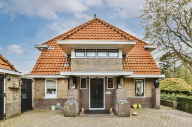 Kaldırımlı tuğladan bir binanın önü ve apartmana açılan ahşap kapılar.