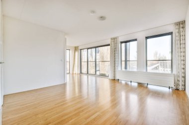 Giriş kapısı, beyaz duvarları ve parke zemini olan geometrik tasarımı olan boş modern bir daire.