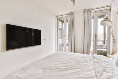 Yatak odasının iç tasarımı, yatak odası ve ahşap gardırop modern dairenin penceresinin kenarına yerleştirilmiş.