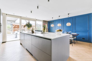 TV 'nin yanındaki koltuklar ve masa, çağdaş apartmandaki geniş odalı yemek alanına karşıdır.