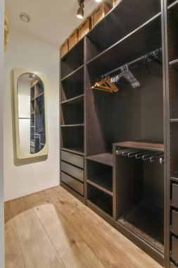 Büyük, karanlık, ferah bir gardırop ve parke zeminli bir oda aynası.