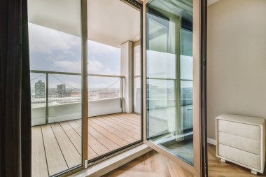 Balkon kapısının yanında rahat bir yatak, evdeki rahat yatak odasında perdeler var.