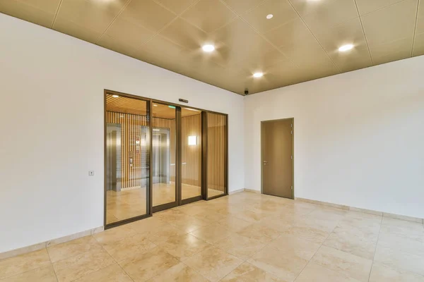 Stylish hallway with door and window to light elevator area in modern apartment