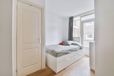 Modern apartmandaki pencerenin yanındaki yatak odasının iç tasarımı