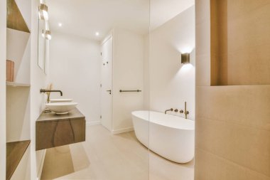 Aynalı lavabo ve temiz küvet modern banyoda cam kapılı ve beyaz fayanslı duvarları olan duş kutusunun yanında.