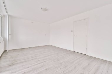 Giriş kapısı, beyaz duvarları ve parke zemini olan geometrik tasarımı olan boş modern bir daire.