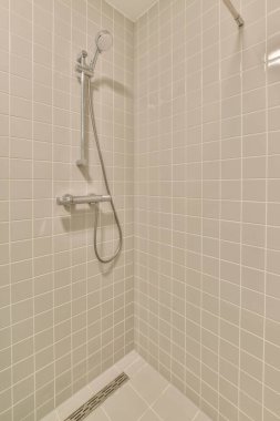 Duşu, tuvaleti ve lavabosu olan çağdaş bir banyo.