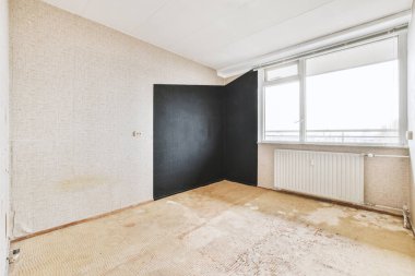 Evdeki boş ışık odasında, beyaz duvardaki plastik pencere ve radyatör.