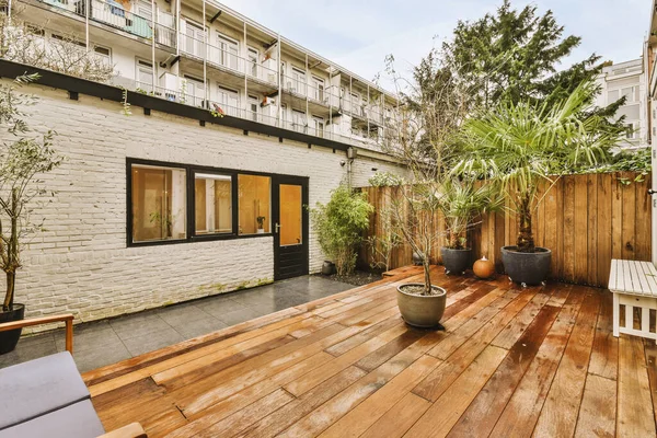 Backyard Deck of modern European house. High quality photo. Wooden deck with cloudy skies and green trees