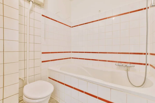 Cuarto Baño Con Paredes Azulejos Blancos Acentos Rojos Inodoro Empotrado — Foto de Stock