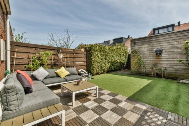 Açık hava eğlencesi için yemek alanı olan minimalist, parlak ve manzaralı bir arka bahçe.