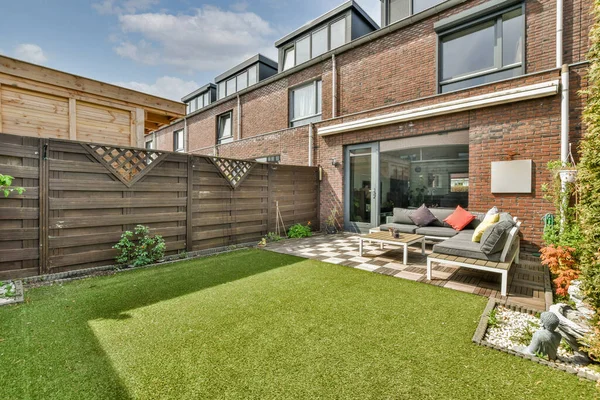 Açık hava eğlencesi için yemek alanı olan minimalist, parlak ve manzaralı bir arka bahçe.