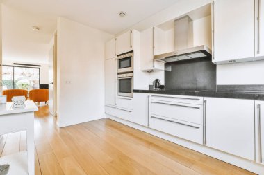 Minimalist tarzı beyaz mobilyalı, lavabolu ve sobalı bir ev mutfağı.