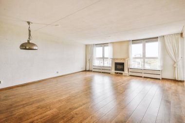 Elektrikli şöminesi, perdesi ve parke zemini olan pencereleri olan ferah ışık odasının içi