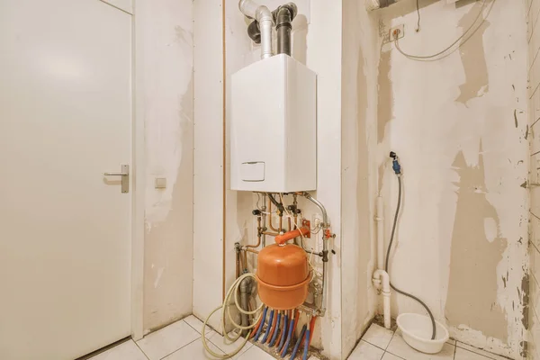 Boiler room of an apartment building with a boiler, pipes and metering devices. Small room with utilities in a modern apartment